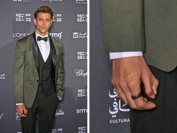 Hrithik Roshan in an olive suit and white shirt, poses for cameras at an event.
