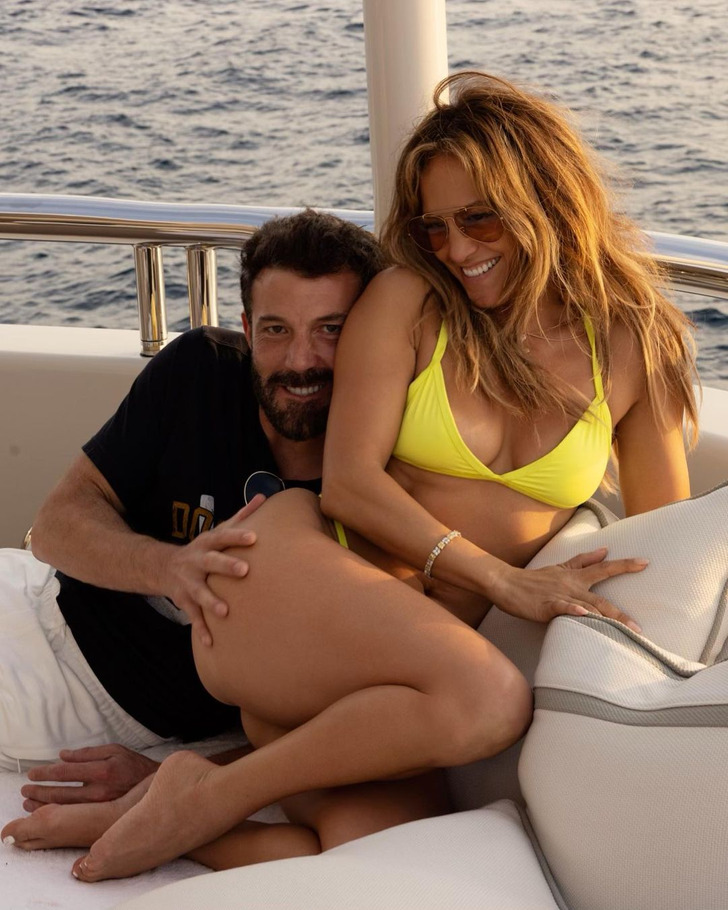 Jennifer Lopez and Ben Affleck on a boat. Affleck has his hand on Jennifer's butt.